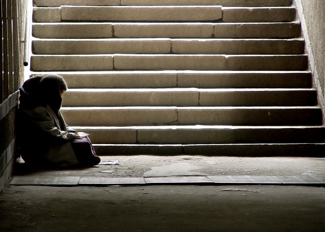 A woman sheltering in a dark tunnel