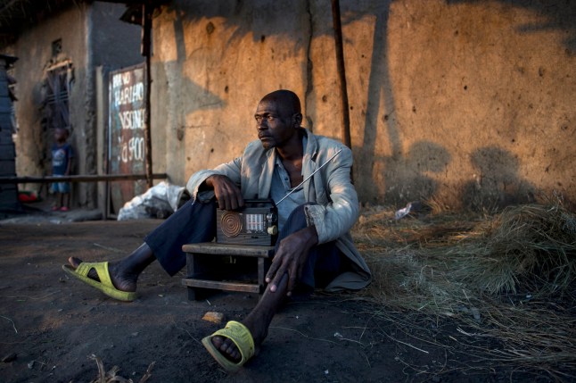 TOPSHOT - A man listens to the news on the radio in an opposition neighbourhood of Bujumbura, on July 22, 2015, following the presidential election of July 21. Burundi counted votes July 22 a day after a presidential election marred by violence and international condemnation that is expected to see incumbent Pierre Nkurunziza win a controversial third term. AFP PHOTO/PHIL MOORE (Photo by PHIL MOORE / AFP) (Photo by PHIL MOORE/AFP via Getty Images)