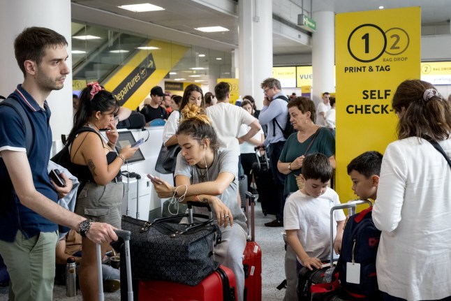 Passengers queueing at Gatwick Airport departure lounge.