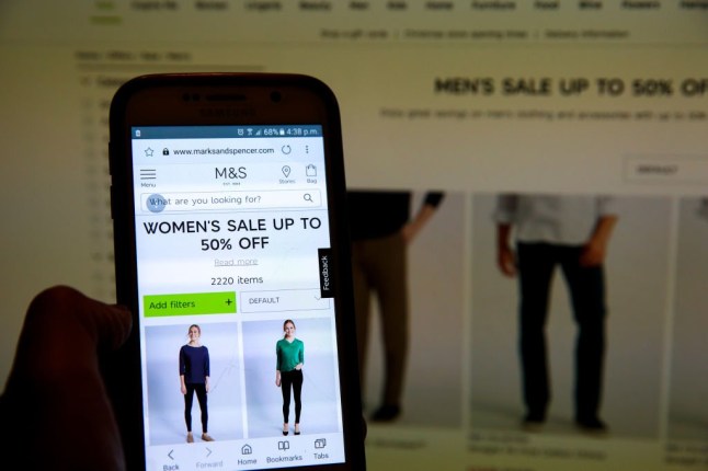 LONDON, UNITED KINGDOM - 2018/12/24: In this photo illustration, the Marks & Spencer Boxing Day online sale is seen on a computer and mobile phone. Boxing Day online sales has begun in many high street stores as shops try to make up for week trading in the lead-up to Christmas. Bigger discounts than normal are expected in the traditional Boxing Day sales in stores and management consultancy Deloitte predicts an average discounts of at least 52% off. (Photo Illustration by Dinendra Haria/SOPA Images/LightRocket via Getty Images)