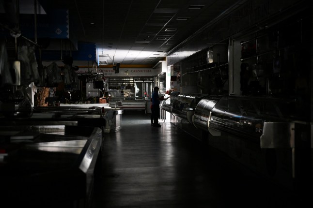A man and a child walk through a local market during a massive power cut in Vigo, northwestern Spain, on April 28, 2025. A massive power cut a massive power cut affects the whole of the Iberian Peninsula and part of France on April 28, 2025, according to Portuguese electricity network operator REN. (Photo by MIGUEL RIOPA / AFP) (Photo by MIGUEL RIOPA/AFP via Getty Images)