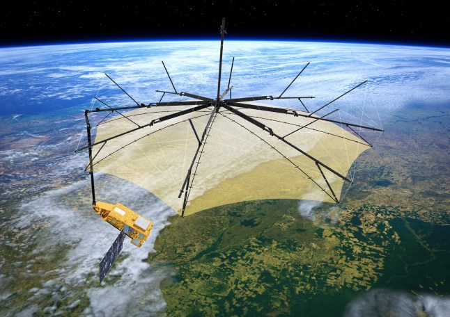 The Biomass satellite that looks like a 'space brolly', pictured over planet Earth.
