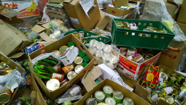 Cardboard boxes with canned foods in cans on dirty floor. Clutter, trash and scattered goods. Mess. Disposal of spoiled products. Trash in supermarket. Store.