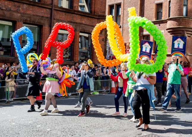 MANCHESTER, ENGLAND - AUGUST 24: Parade goers enjoy the Manchester Pride Parade 2024 on August 24, 2024 in Manchester, England. (Photo by Shirlaine Forrest/Getty Images)