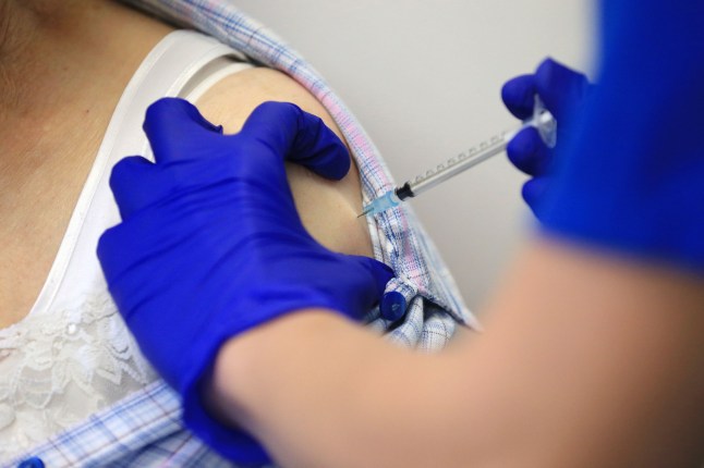 TOPSHOT - Nurse Practitioner Terri Welch administers a dose of the Pfizer-BioNTech Covid-19 vaccine to a patient at the Haxby and Wigginton Group Medical Practice in Haxby, northern England on December 22, 2020. - Europe is expected to start a massive vaccination campaign after Christmas following the United States and Britain, which have begun giving jabs with an approved Pfizer-BioNTech shot, one of several leading candidates. (Photo by Lindsey Parnaby / AFP) (Photo by LINDSEY PARNABY/AFP via Getty Images)