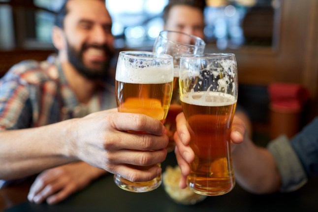people, men, leisure, friendship and celebration concept - happy male friends drinking beer and clinking glasses at bar or pub; Shutterstock ID 464199170; purchase_order: -; job: -; client: -; other: - 14586435