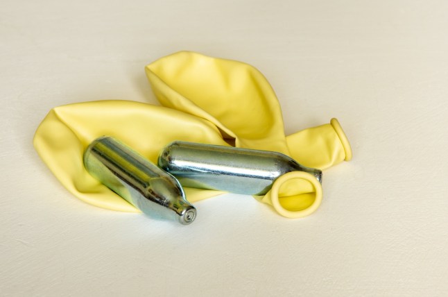 Pair of Nitrous Oxide or laughing gas canisters and two ballons used for sniffing.