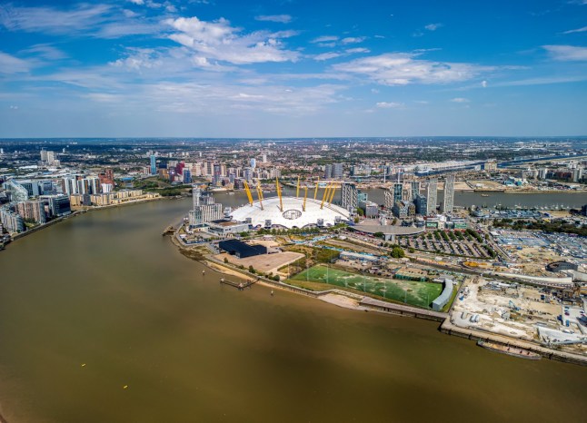 London, UK- August 28, 2024:???The drone aerial view of Greenwich Peninsula and River Thames.???The Greenwich Peninsula is an area of Greenwich in South East London, England.