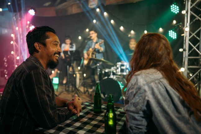 Young people celebrating a party,drinks while having fun at the live music at night.