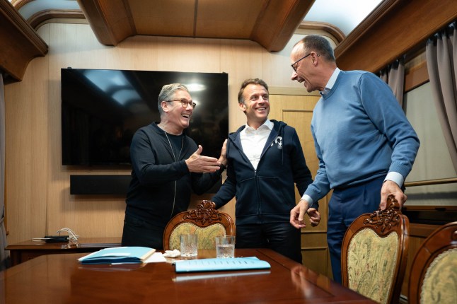 Britain's Prime Minister Keir Starmer (L) gestures during a trilateral meeting France's President Emmanuel Macron (C) and German Chancellor Friedrich Merz (R) on board a train to Kyiv, in Shegyni, Ukraine, on May 9, 2025. (Photo by Stefan Rousseau / POOL / AFP) (Photo by STEFAN ROUSSEAU/POOL/AFP via Getty Images)
