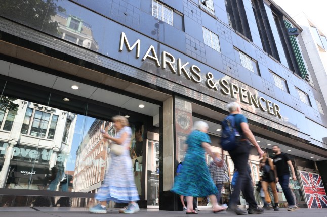 Shoppers pass Marks & Spencer on a high street.