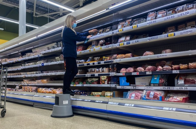A staff member on an isle at a Tesco store.
