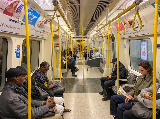 Passengers sitting in Tube carriage on the London Underground District Line.