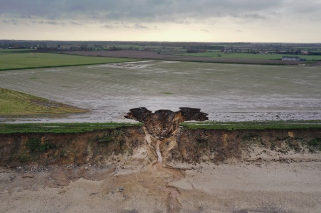 HAPPISBURGH, ENGLAND - JANUARY 27: A recent landslip on the cliff edge and beach in the village of Happisburgh on January 27, 2021 in Happisburgh, England. Erosion of the Norfolk sandy cliffs and sand dunes has caused many buildings and farmland to be lost to the sea. The effects of global climate change causing storms and sea swells has seen the East Coast of the United Kingdom lose up to one metre of coast line each year. (Photo by Christopher Furlong/Getty Images)