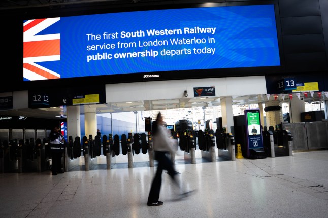 People walk past signage at Waterloo train station in central London as South Western Railway (SWR) becomes the first rail operator to be renationalised under the Labour Government's Passenger Railway Services (Public Ownership) Act 2024. Picture date: Sunday May 25, 2025. PA Photo. See PA story RAIL Renationalisation. Photo credit should read: James Manning/PA Wire