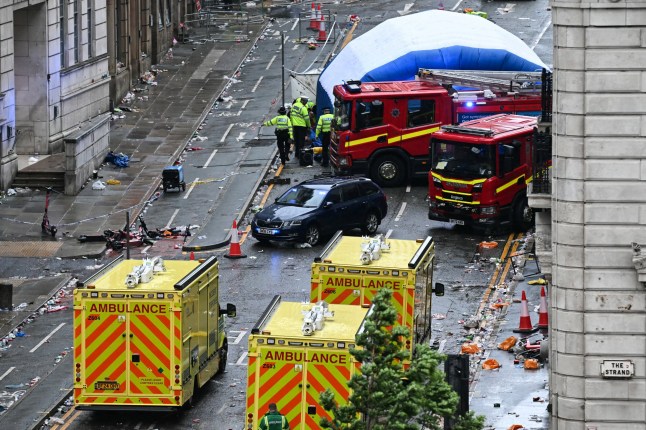 Police officers cover with an inflatable tent, behind a firefighter vehicle, the tents delimiting the scene of an incident in Water Street, on the sidelines of an open-top bus victory parade for Liverpool's Premier League title win, in Liverpool, north-west England on May 26, 2025. A car collided with a number of pedestrians in Liverpool, northern England, on May 26 evening during Liverpool FC's Premier League victory parade, police said. Police said they were contacted shortly after 6pm (1700 GMT) 'following reports of a collision between a car and a number of pedestrians' in the city centre. One man has been arrested, according to the police, who did not say whether there were any casualties. (Photo by Paul ELLIS / AFP) (Photo by PAUL ELLIS/AFP via Getty Images)