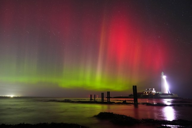 The sky is filled with colour from the aurora borealis, also known as the Northern Lights, at St Mary's lighthouse in Whitley Bay on the North East coast of England. Picture date: Wednesday March 26, 2025. PA Photo. Photo credit should read: Owen Humphreys/PA Wire