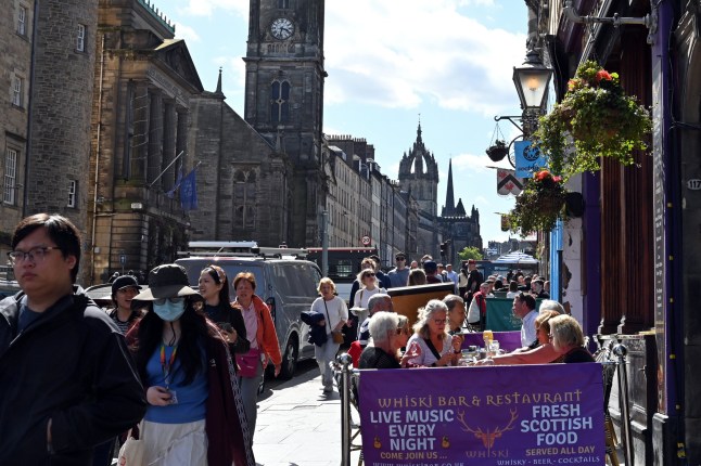 EDINBURGH, SCOTLAND - MAY 22: People enjoy the sunshine on the Royal Mile, as much of Scotland continues to experience fine Spring weather, on May 22, 2025 in Edinburgh, Scotland, United Kingdom. (Photo by Ken Jack/Getty Images)