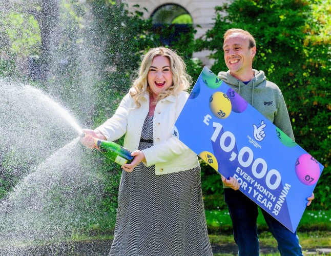 Olivia and Kevin holding the Lottery sign.