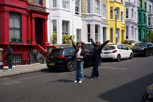 London, UK, 4th June, 2025. Residents of Lancaster Road have painted their houses black in an attempt to dissuade tourists from taking selfies in front of their properties. The street has become a magnet for social media influencers and tourists. Picture shows tourists talking photographs and ???selfies??? in front of the multi-coloured houses.