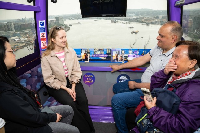 People chatting and laughing inside the IFS Cloud Cable Car in London.