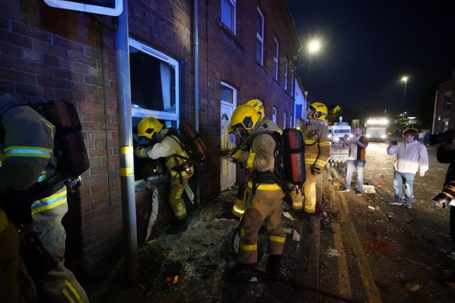 Fire fighters check houses in Ballymena, as people take part in a protest over an alleged sexual assault in the Co Antrim town. Police used water cannon to disperse protesters engaged in serious disorder for a second night in Ballymena, as fireworks and masonry were thrown at officers. Picture date: Tuesday June 10, 2025. PA Photo. See PA story ULSTER Ballymena. Photo credit should read: Niall Carson/PA Wire