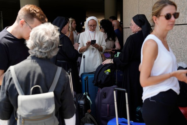 Citizens of Poland and Austria assemble at a hotel in Tel Aviv, Israel, for evacuation amid heavy strikes on Israel by Iran Tuesday, June 17, 2025. (AP Photo/Baz Ratner)