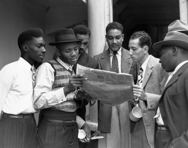 A group of Jamaican men reading a newspaper aboard the HMT Empire Windrush on arrival at Tilbury in Essex, 22nd June 1948. (Photo by Douglas Miller/Keystone/Hulton Archive/Getty Images)