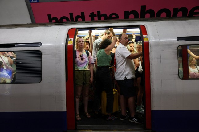 People stand in a train car at King's Cross St. Pancras underground station as temperatures are due to hit 30C today in London, Britain, June 21, 2025. REUTERS/Isabel Infantes
