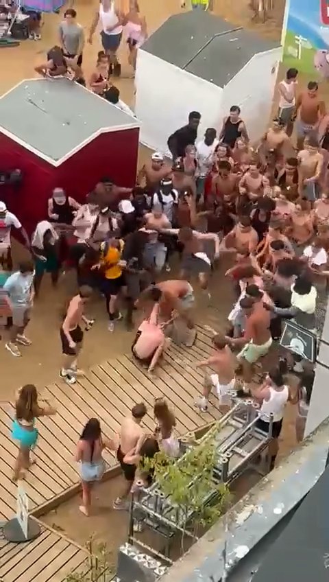 Another moment of the brawl, in which a person has fallen to the ground and is circled by a large crowd.