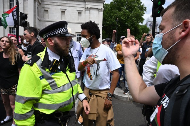 LONDON, ENGLAND - JUNE 23: (EDITOR'S NOTE: Image contains profanity.) A protestor gestures towards police during a Palestine Action demonstration at Trafalgar Square on June 23, 2025 in London, England. Members of the Palestine Action (PA) campaign group have called an emergency demonstration as Home Secretary Yvette Cooper reportedly prepares to proscribe the group, which would make it unlawful to join the organization. On Friday, June 20, members of Palestine Action broke into RAF Brize Norton on e-scooters and sprayed two Voyager planes with red paint. The group has repeatedly targeted arms manufacturers and government and financial institutions it says are contributing to Israel's military campaign against Palestinians. (Photo by Leon Neal/Getty Images)