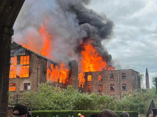 Plumes of smoke seen for MILES as fire ravages historic Manchester Hotspur Press building