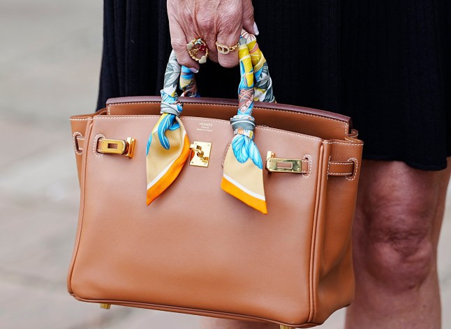 A Hermes handbag carried by fraud victim Christine Colbert, owner of Dress Cheshire, who was defrauded of ?43,800, outside Chester Crown Court, in Chester, after Jack Watkin, 26, of Alderley Edge, Cheshire, pleaded guilty to fraud after offering a business opportunity to people who would loan him large sums of money, with the promise it would be used to buy exclusive Hermes handbags he would sell on at profit. Watkin, who claimed to be a millionaire defrauded people, including his father, Jason Watkin, out of thousands of pounds which he promised would be used to buy and sell designer handbags, the court has heard. He was remanded in custody before his sentence on September 3. Picture date: Tuesday June 24, 2025. PA Photo. Photo credit should read: Peter Byrne/PA Wire