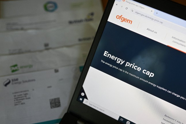 In this arranged photograph the website of Britain's energy regulator Ofgem, is displayed on the screen of a laptop, next to energy bills on a desk in a residential property in Guildford, south of London on August 21, 2024. Britain's Energy regulator Ofgem will on August 23, announce the latest quarterly energy price cap, for October to December, with average household energy bills predicted to rise again. (Photo by Justin TALLIS / AFP) (Photo by JUSTIN TALLIS/AFP via Getty Images)