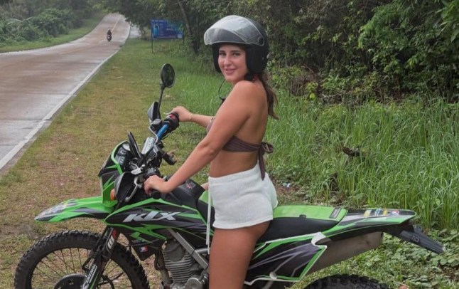 A photograph of Bella Culley in a helmet straddling a motorbike