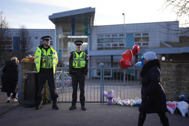 File photo dated 5/2/2025 of Police officers and floral tributes outside All Saints Catholic High School, on Granville Road in Sheffield, South Yorkshire, after 15-year-old Harvey Willgoose died following a stabbing incident at the school. A 15-year-old boy who stabbed another teenager at a school is due to go trial accused of murder. Harvey, also 15, died after he was stabbed through the heart at All Saints Catholic High School in Sheffield on February 3. A teenager, who cannot be named, has admitted Harvey's manslaughter but denies murdering the Sheffield United fan and will go on trial at Sheffield Crown Court on Monday. Issue date: Monday June 30, 2025. PA Photo. Photo credit should read: Jacob King/PA Wire