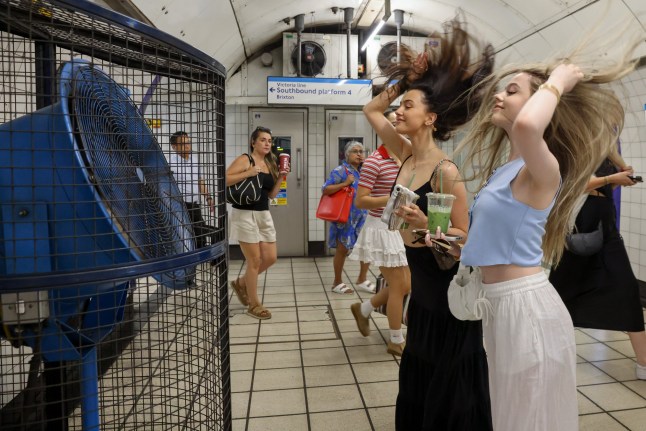 ? Licensed to London News Pictures. 01/07/2025. London, UK. Two sisters cool off in front of a large fan at a London Underground station as the heatwave continues. Temperatures on the trains and in the Underground are higher than at ground level. An amber heat warning has been issued for London, with temperatures expected to soar to 34?C as a heatwave sweeps across the UK. Photo credit: Dinendra Haria/LNP