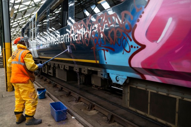 Train presentation teams clean the trains before service during Wimbledon at the Southwestern Railways Wimbledon depot. Picture: Jeff Asiedu - train presentation operative cleans graffiti from a Southwestern train. ?? Lucy Young 2025 07799118984 lucyyounguk@gmail.com www.lucyyoungphotos.co.uk