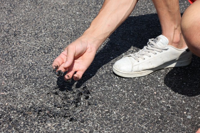 Mark Edwards holding piece of tarmac that has melted in heatwave on Gorsemoor Road in Cannock. Gorsemoor Road in Cannoc in Staffordshire is melting down in the heatwave. The highways authority has temporarily closed the road, and has been out on Saturday to treat it . Photo released 13/07/2025