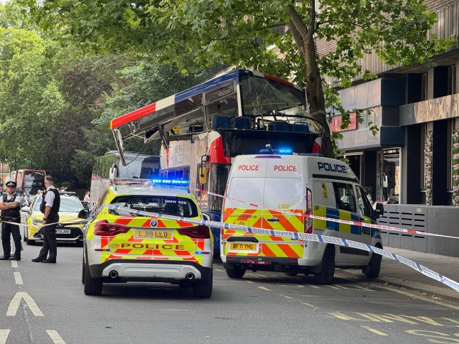A hop-on hop-off London tour bus packed with tourists has crashed in central London, just yards from the historic 7/7 bomb site, injuring several people and triggering a major emergency response. The collision occurred at around 2:40pm this afternoon, when the open-top double-decker bus struck a tree during a sightseeing route near Tavistock Square. The force of the impact crumpled the roof of the upper deck, trapping at least six people, including a young girl, inside the mangled wreckage. Emergency Services Rush to the Scene Multiple fire engines, ambulances, and paramedic units from the London Ambulance Service and London Fire Brigade rushed to the scene. Firefighters used specialist cutting tools to free the trapped passengers, working urgently to secure the damaged upper deck. Witnesses described scenes of ???carnage onboard???, with the bus suddenly jolting and a loud bang echoing across the area. ???I thought a bomb had gone off,??? said one nearby shop worker. ???The noise was horrific ??? metal twisting, glass shattering ??? total chaos. Then people started screaming.??? Location: Near Tavistock Square The crash occurred near Tavistock Square, the site of the devastating 2005 London bus bombing, heightening alarm among those nearby. Police quickly cordoned off the area, reassuring the public that this incident was unrelated to terrorism. Sightseeing Tour Turns to Panic The bus was part of a Hop-on Hop-off sightseeing tour, popular with visitors wanting to explore iconic landmarks at their own pace. It is understood the vehicle collided with a low-hanging tree while in motion, causing catastrophic damage to the roof section. The London Fire Brigade confirmed that the vehicle was made safe shortly after the incident. ??Investigation Underway The Metropolitan Police???s Commercial Vehicle Unit, along with Roads and Transport Policing Command, has launched an investigation into the cause of the crash. Engineers are examining the bus, and CCTV fo