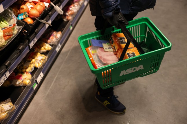A shopper carrying a shopping basket at the Asda Express convenience store, operated by Asda Group Ltd., in London, UK, on Tuesday, Dec. 13, 2022. Asda is accelerating its push into convenience stores as the UK's third-largest supermarket operator seeks to expand its market share. Photographer: Hollie Adams/Bloomberg via Getty Images