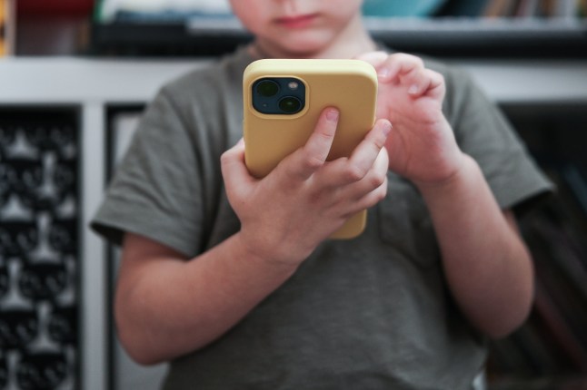 Close up of little child using a mobile phone.