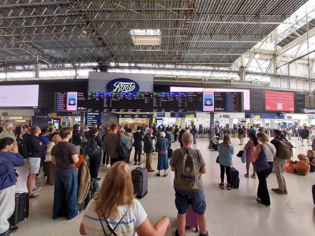 Passengers stood in front of screens at London Waterloo station after cancellations and delays