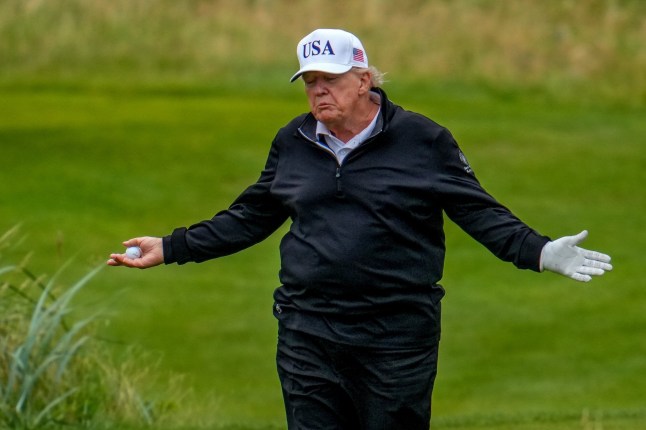US President Donald Trump reacts as he plays a round of golf at Trump Turnberry golf course