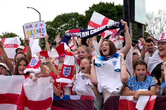 Fans wait with banners and flags to welcome the England Women's national football team at Southend Airport on July 28, 2025, after England beat Spain 3-1 on penalties to lift the Women's Euro 2025 trophy. (Photo by CARLOS JASSO / AFP) (Photo by CARLOS JASSO/AFP via Getty Images)