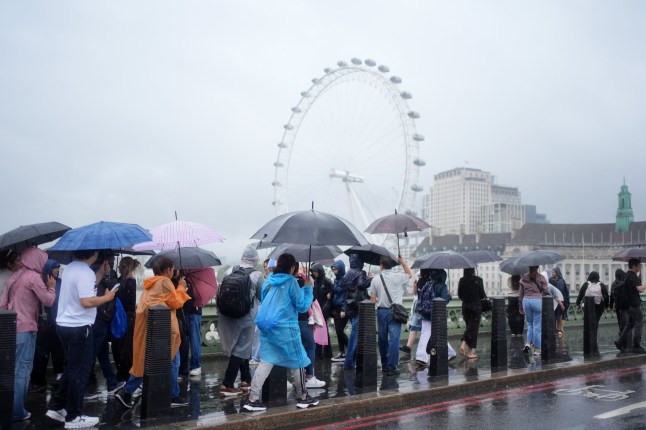 People using umbrellas whilst walking in the rain on Westminster Bridge, in London. An amber weather warning has come into force with dangerous thunderstorms threatening to bring a weekend of flooding to parts of the UK. Picture date: Saturday July 19, 2025.