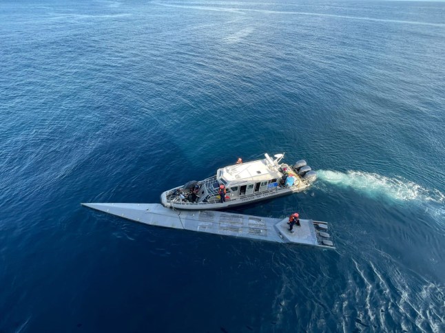Picture shows Colombian Police boat next to a submarine transporting 2643 kilograms of cocaine, undated. Two bodies and two suspects in poor health from inhaling toxic gases from the fuel were found onboard in the Pacific, by Colombian Police. (Colombian Navy/Newsflash )