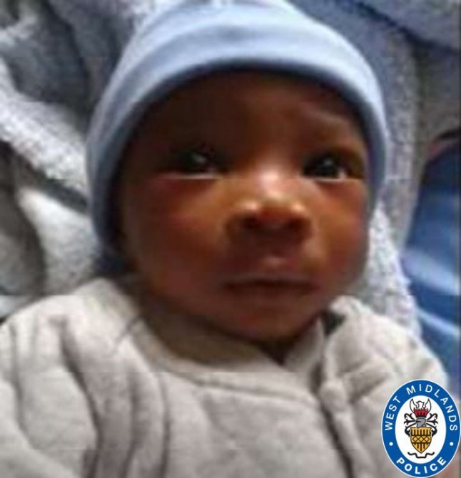 A baby picture of Abiyah, wearing a blue hat and grey babysuit.