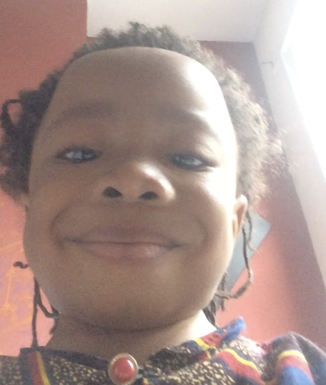 A photograph of Abiyah's head and shoulders, smiling down at the camera.