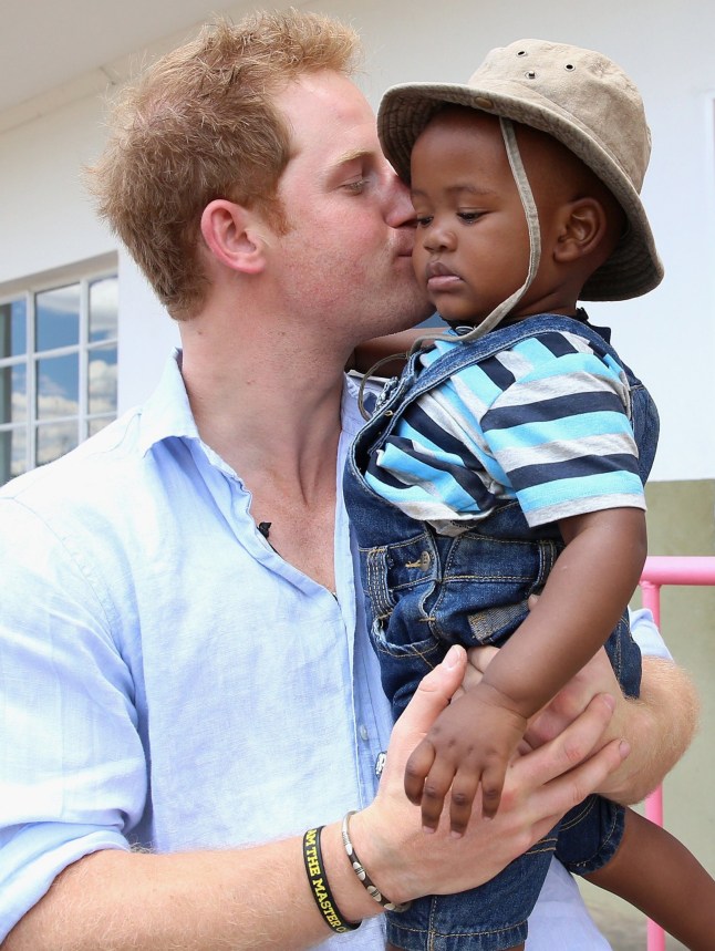 BUTHA-BUTHE, LESOTHO - DECEMBER 07: Prince Harry holds a young child during a visit to Thuso Centre for children living with multiple disabilities on December 7, 2014 in Bute-Bute, Lesotho. Prince Harry was visiting Lesotho to see the work of his charity Sentebale. Sentebale provides healthcare and education to vulnerable children in Lesotho, Southern Africa. The particular theme of his visit was to check on the progress of the Mamohato Childrens Centre which will provide vital support to children affected by HIV. Prince Harry founded Sentebale (which means Forget Me Not in Sesotho) with Prince Seeiso in 2006. (Photo by Chris Jackson/Getty Images for Sentebale)